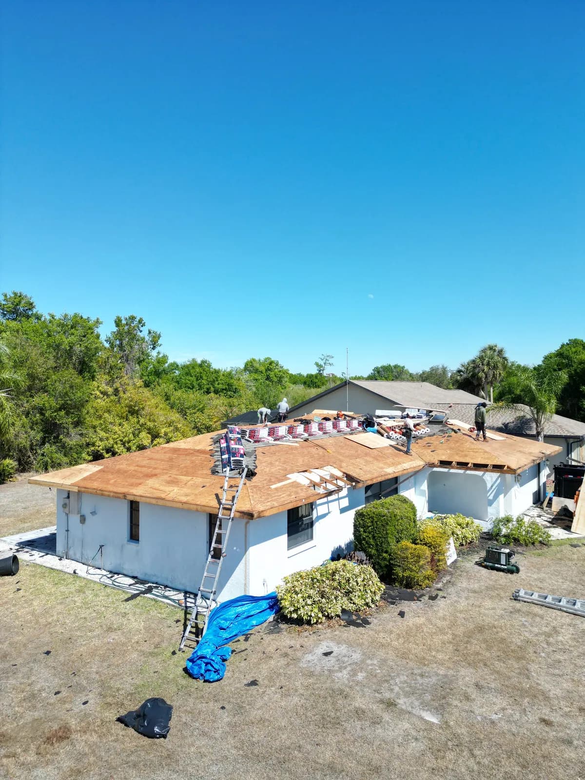 Roofing crew installing new roof with underlayment